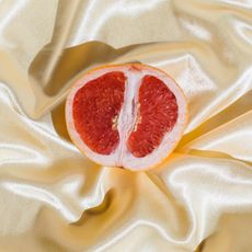 grapefruit on white satin sheets