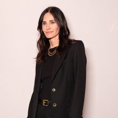 Courteney Cox in front of a step and repeat at Marie Claire's power play event
