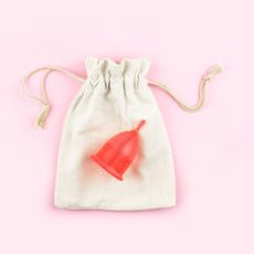 red menstrual cup on a white satchet